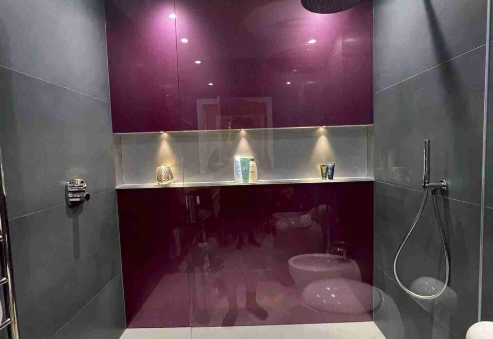 Bathroom with purple colored glass splashbacks on the entire back wall of the shower area in the South West.